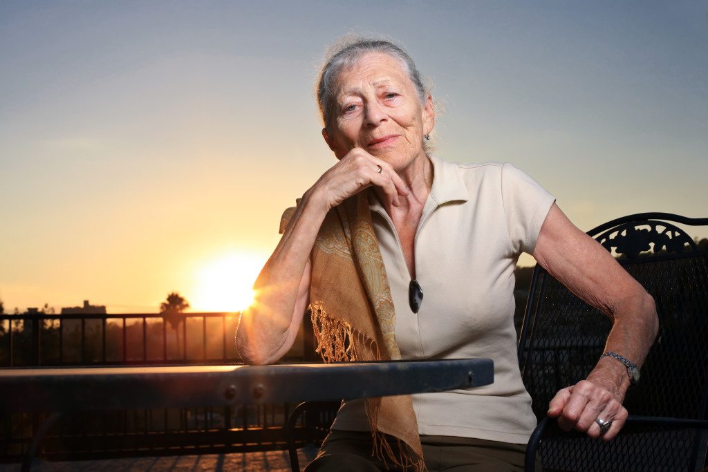Senior woman portrait Senior woman sitting at the table outdoors at sunset.